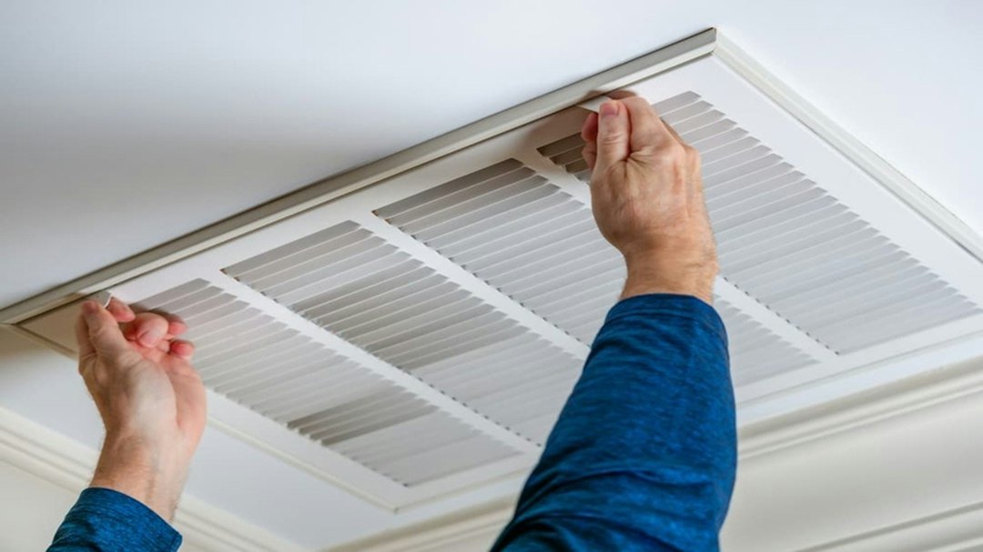 Technician inspecting an air-conditioning unit during a professional maintenance visit
